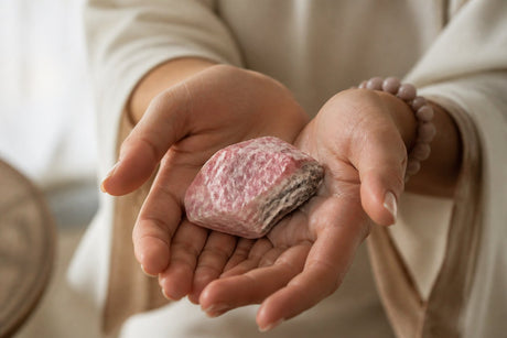 Rodonit natural ținut în mâini